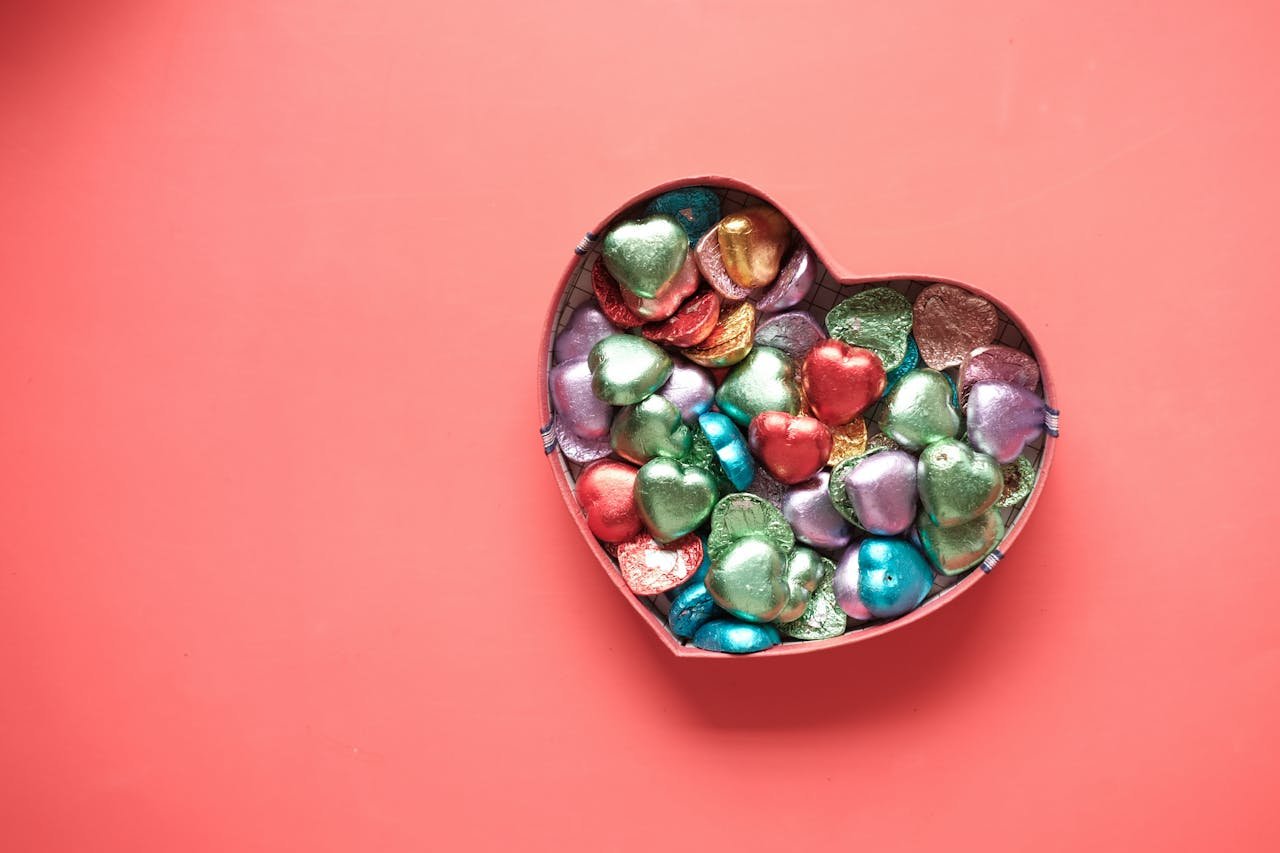 Vibrant heart-shaped chocolates in a heart box on a pink background. Perfect for Valentines Day.